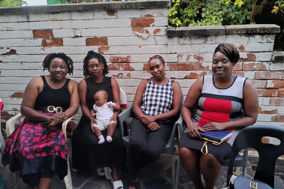 Four women of Great Potential Ladies seated together, one holding a baby