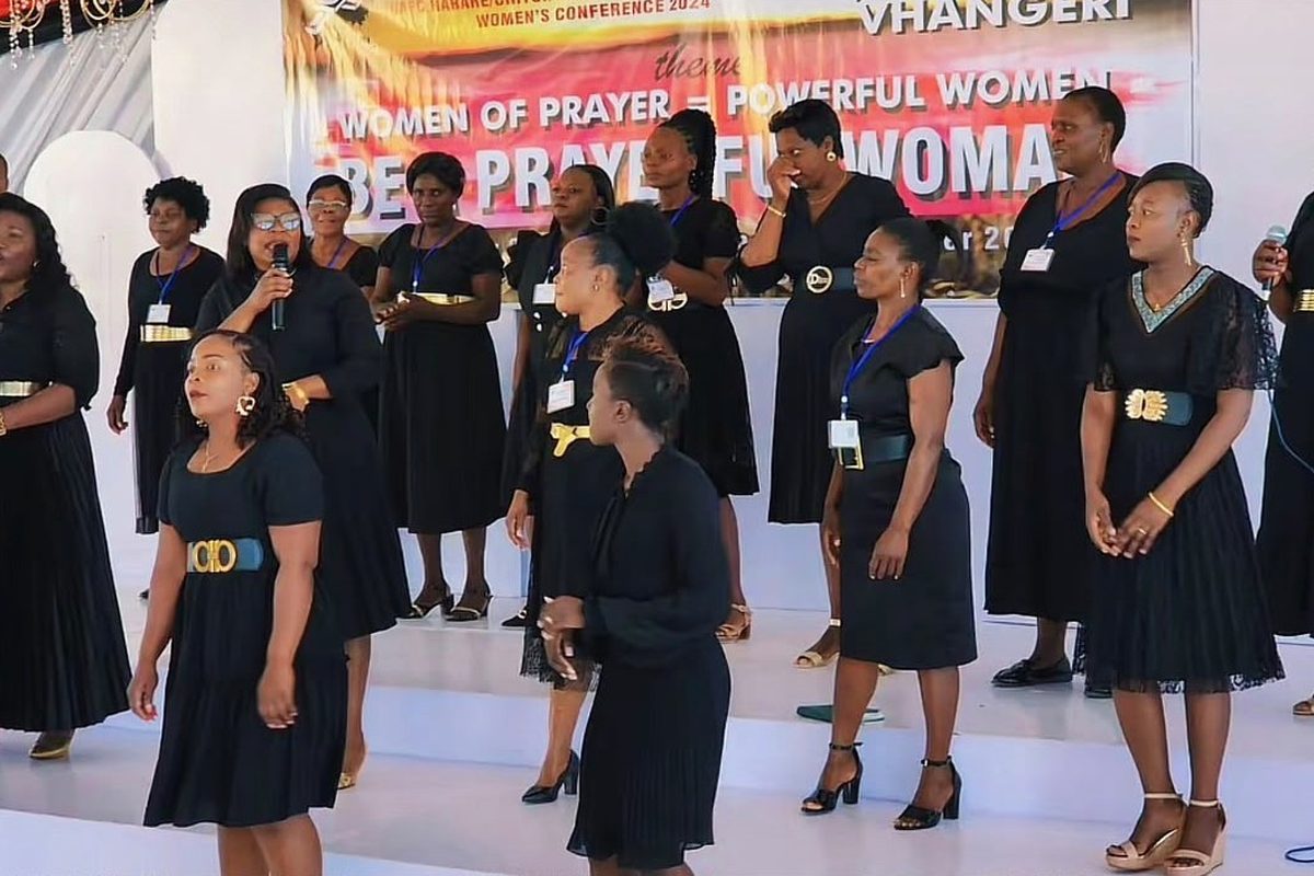 Women in black dresses leading worship on stage at the national women's conference
